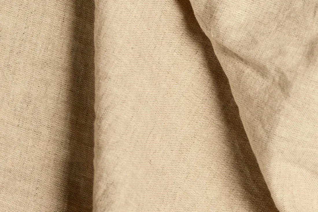 Folds of natural oatmeal linen catching soft, warm light.